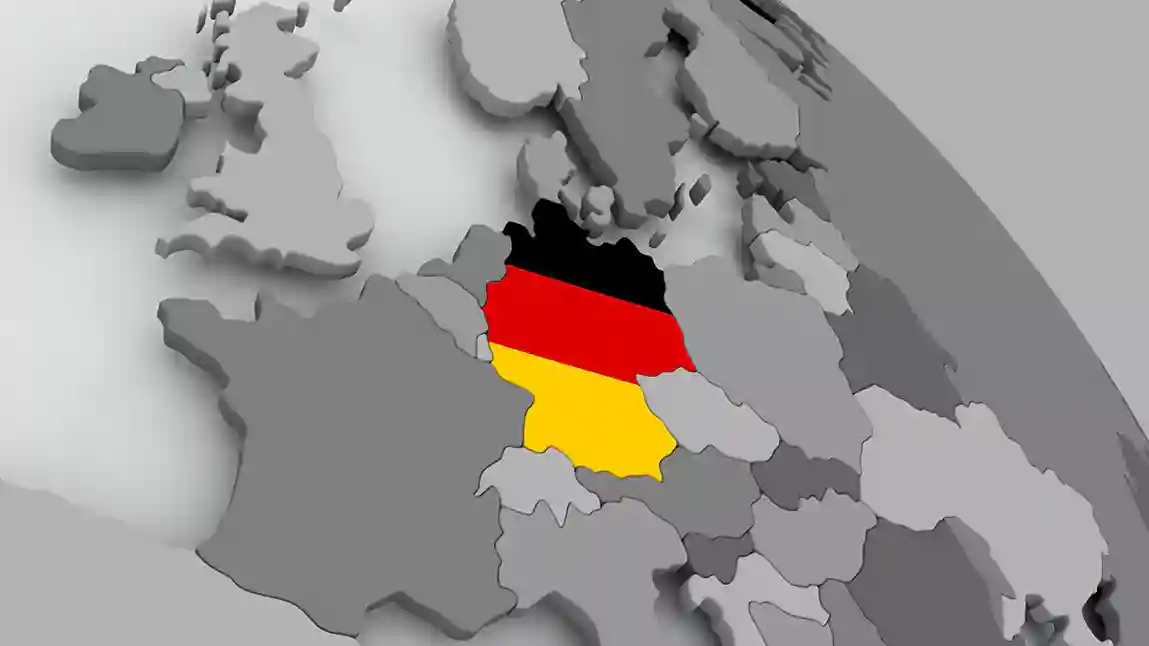 الصورة تتضمن نص تعلم اللغة الألمانية وأعلام العديد من دول العالم وفي الخلفية علم ألمانيا وتعرف على أسماء الدول بالألمانية والجنسيات مع قواعد الاستخدام وأمثلة عملية وقوائم شاملة لتعلم أسماء البلدان وصفات الجنسية بسهولة.