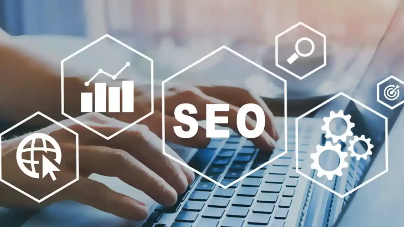 شخص يعمل على لوحة مفاتيح مع أيقونات جرافيك ترمز إلى تحسين محركات البحث SEO والإحصائيات